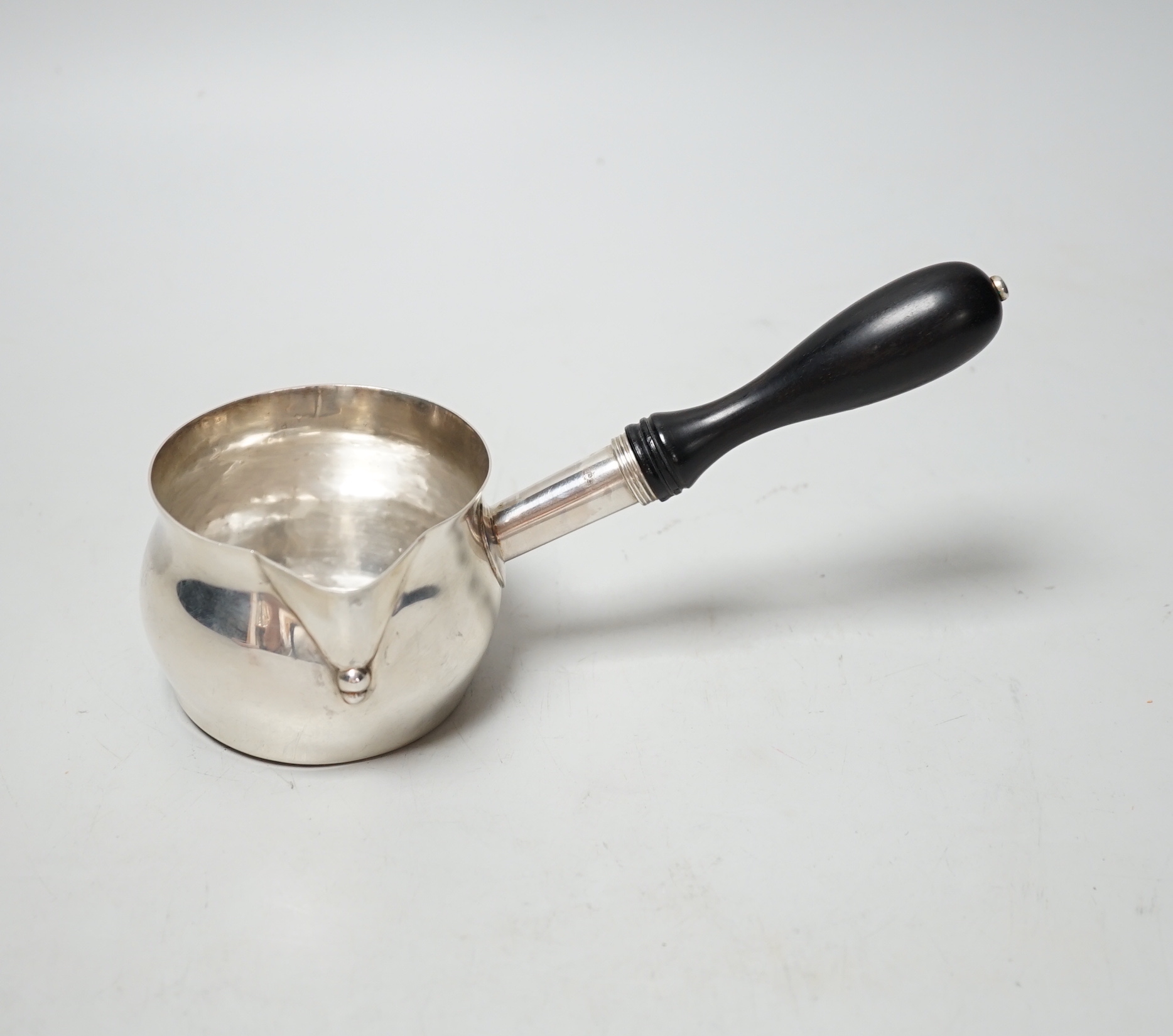 A modern silver brandy pan, with turned ebonised handle, maker, I*R, London 2002, length approx. 19.6cm, gross weight 4.9oz.